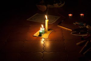 Zapalone świece, w tle karty do wróżenia